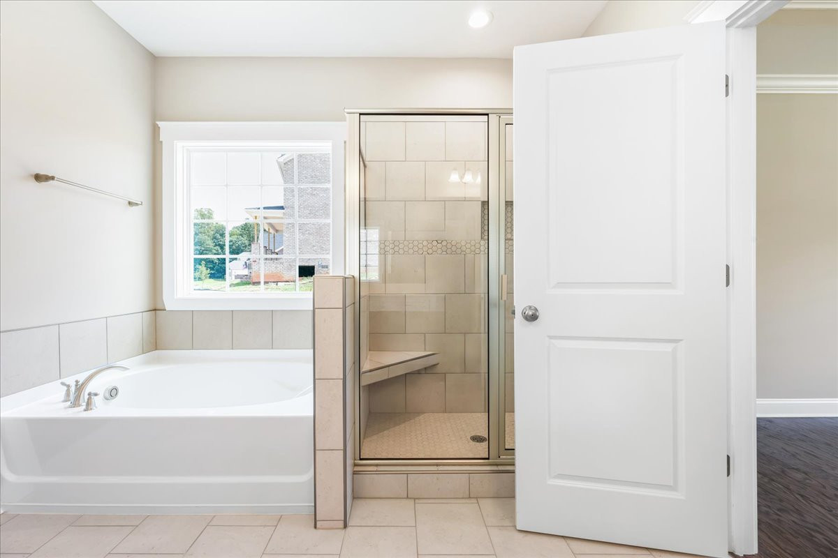 https://assets.windsorhomes.us/img/DA_lot58_Hickory_elvB_8009_Back_Nine_Drive_primary_bath_tub_shower.jpg